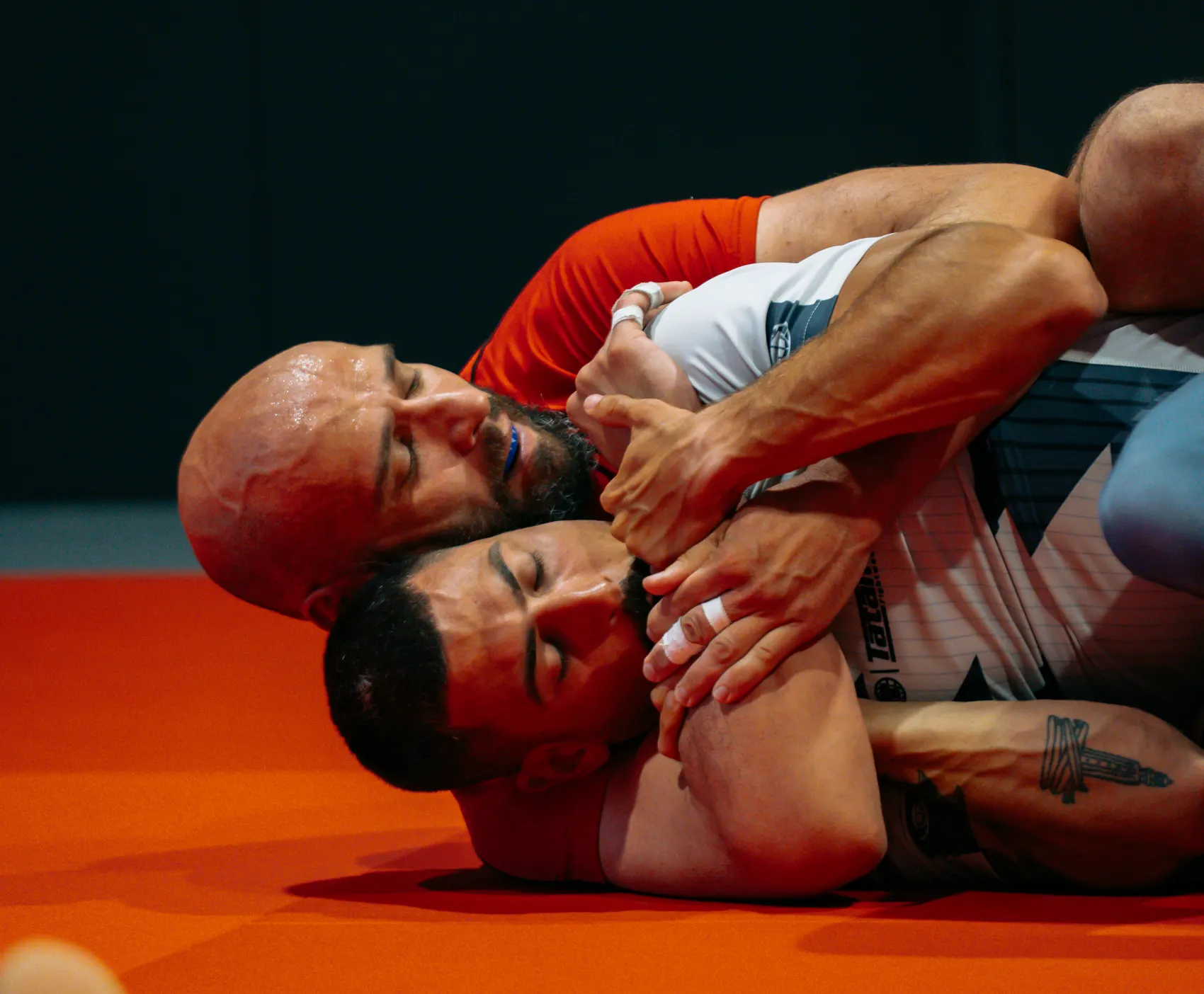 Dos alumnos rodando sin kimono sobre el tatami